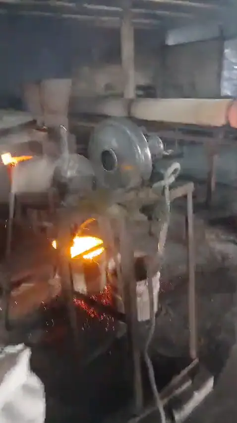 Glowing activated carbon pouring from the kiln into a drum